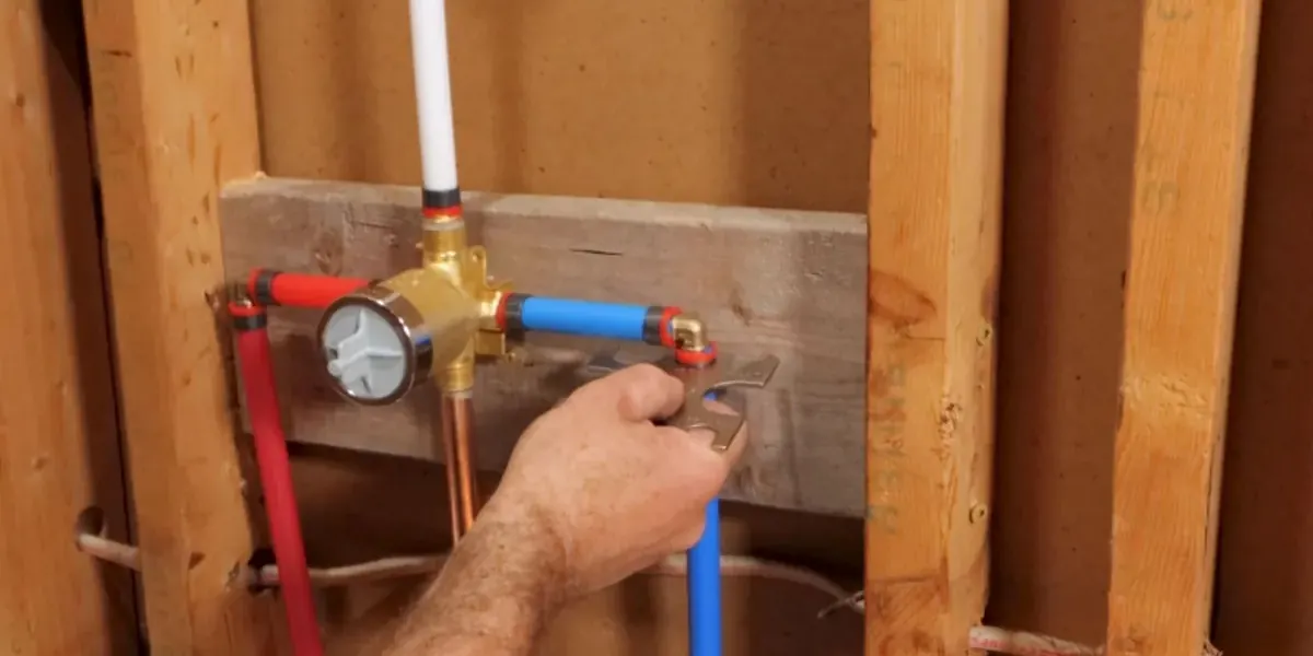 Shower valve with red and blue PEX lines mounted between wall studs